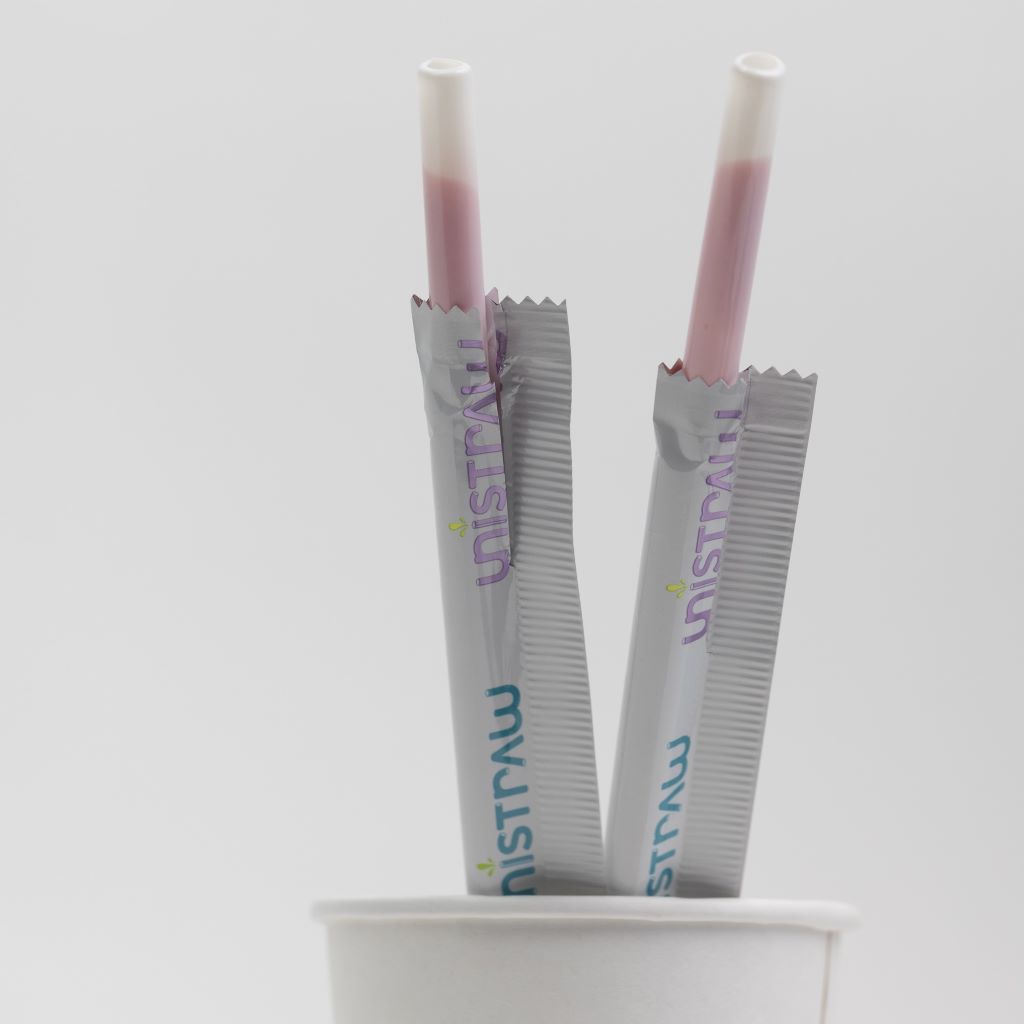 Two Unistraw milk-flavored pink straws in their packaging.